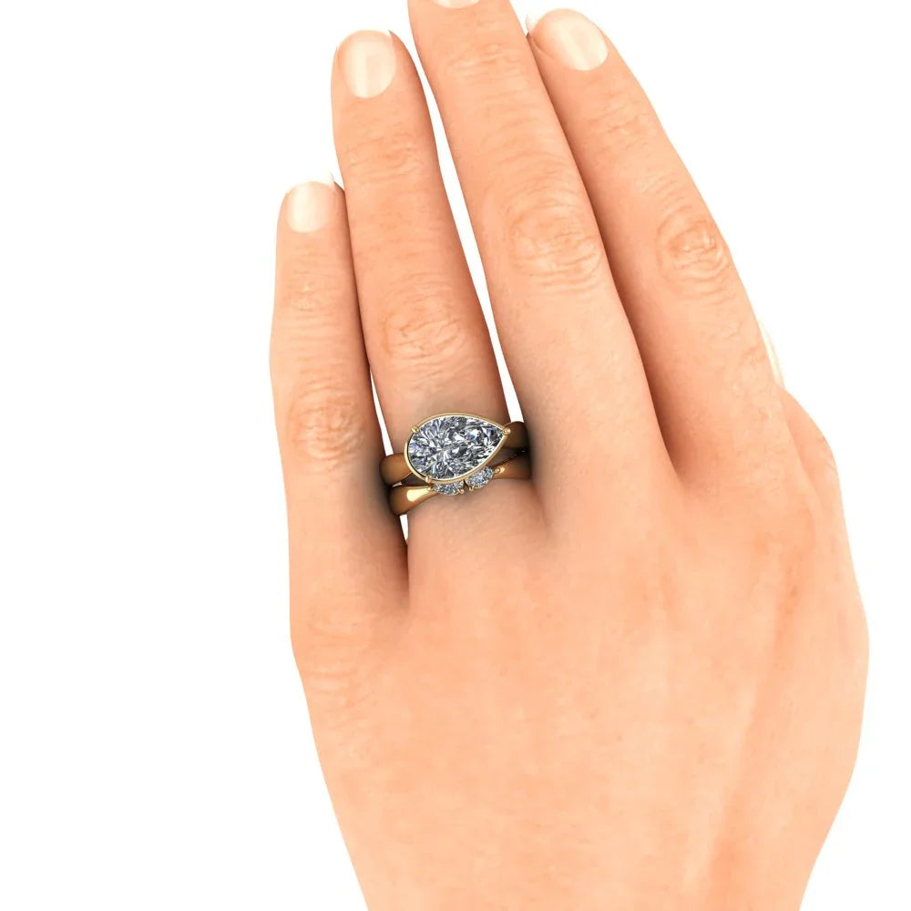 Gold pear-shaped diamond engagement ring set on hand, custom jewelry photography