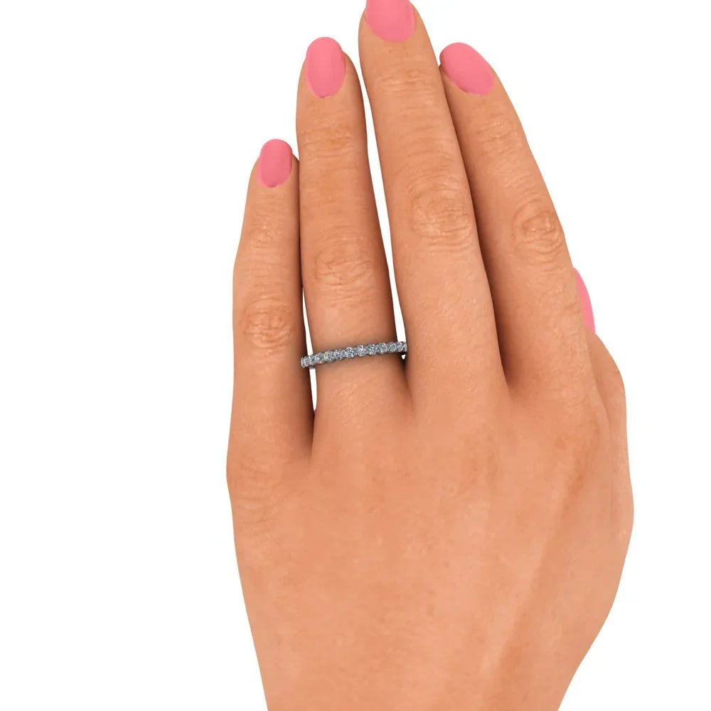 Diamond eternity band on hand with pink nail polish, custom wedding ring jewelry