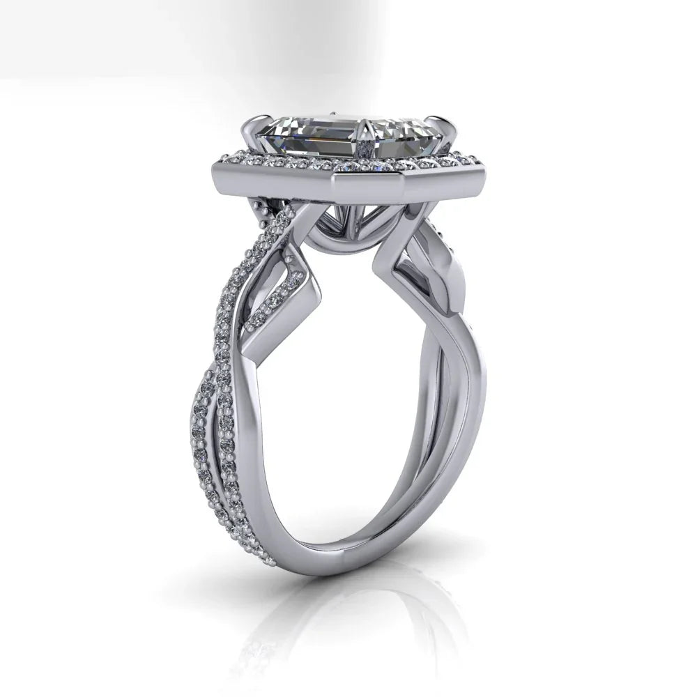 Custom white gold engagement ring with intricate twisting diamond band and emerald-cut center stone