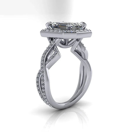 Custom white gold engagement ring with intricate twisting diamond band and emerald-cut center stone