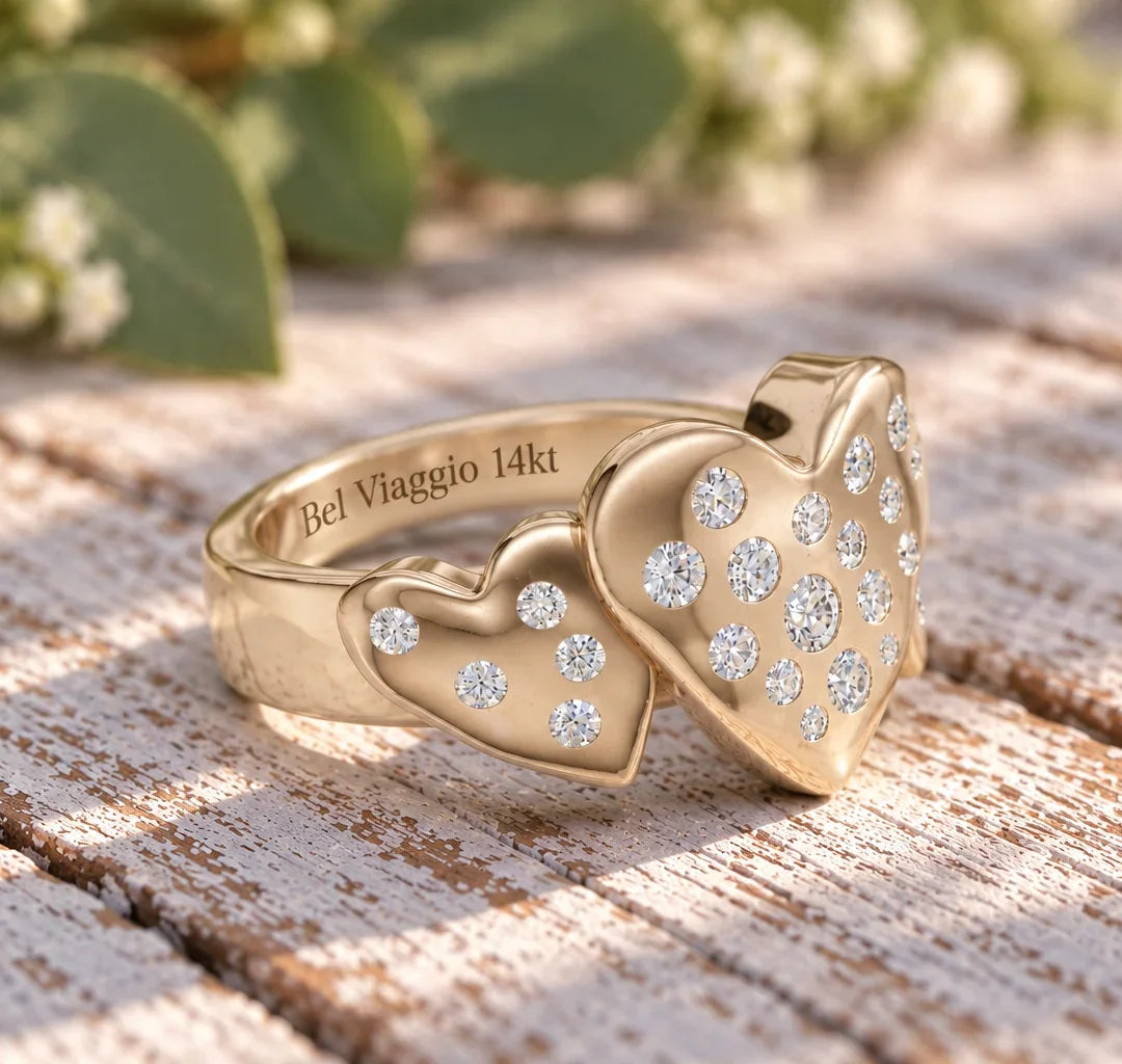 14kt gold ring with two heart-shaped diamond clusters on a weathered wooden surface