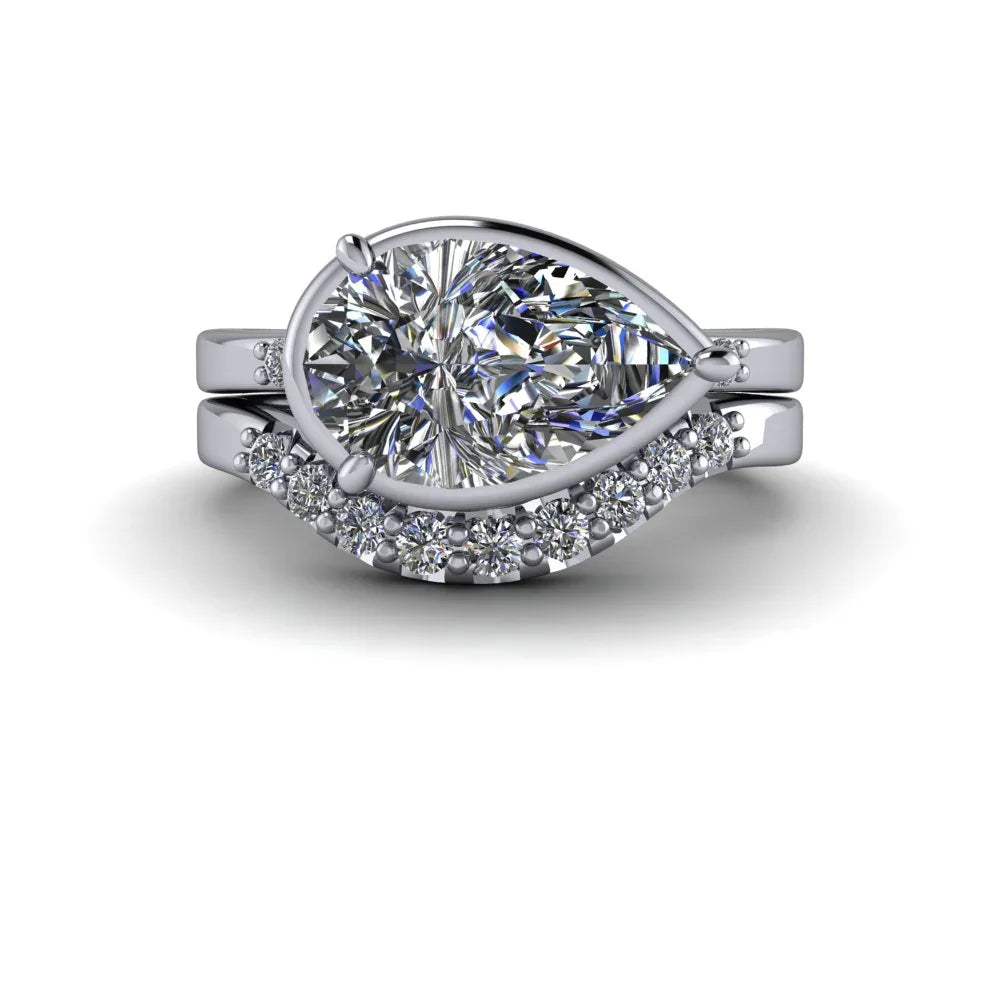 Pear shaped diamond engagement ring set with pavé diamond band on white background