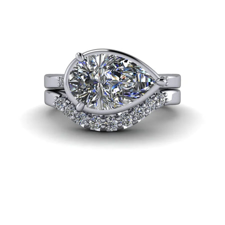 Pear shaped diamond engagement ring set with pavé diamond band on white background