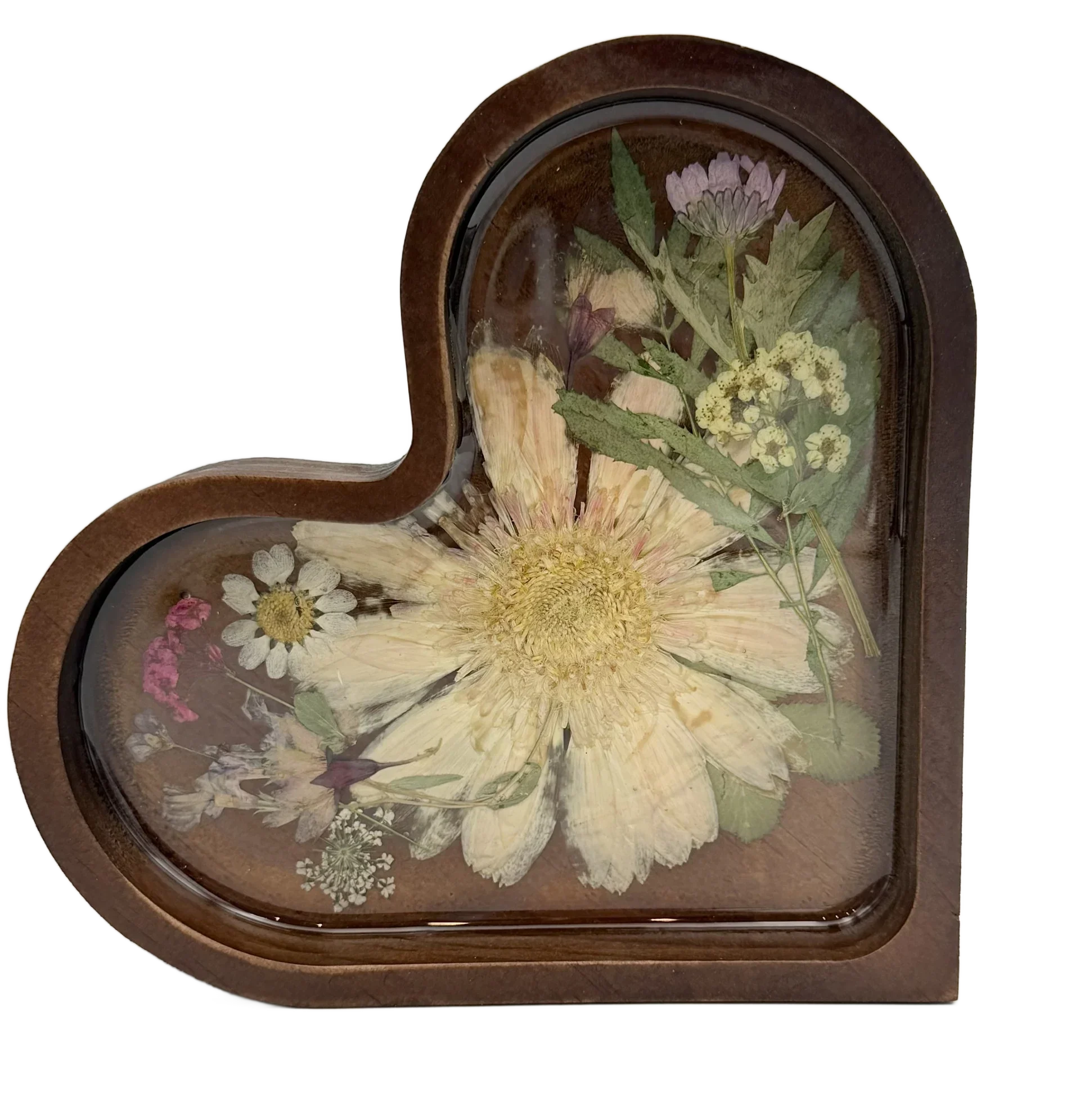Heart-shaped resin keepsake with pressed dried flowers and greenery on a wood base