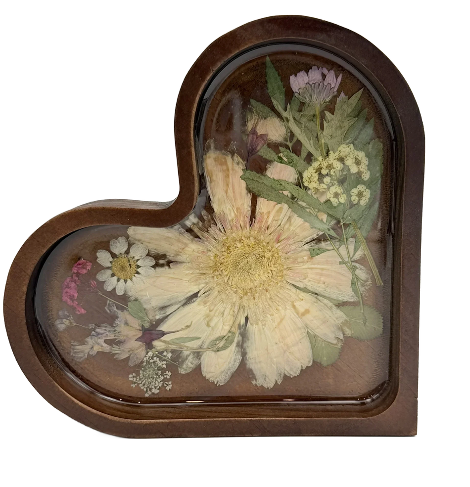 Heart-shaped resin keepsake with pressed dried flowers and greenery on a wood base
