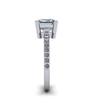 Side view of white gold engagement ring with emerald-cut center stone and pavé diamond band