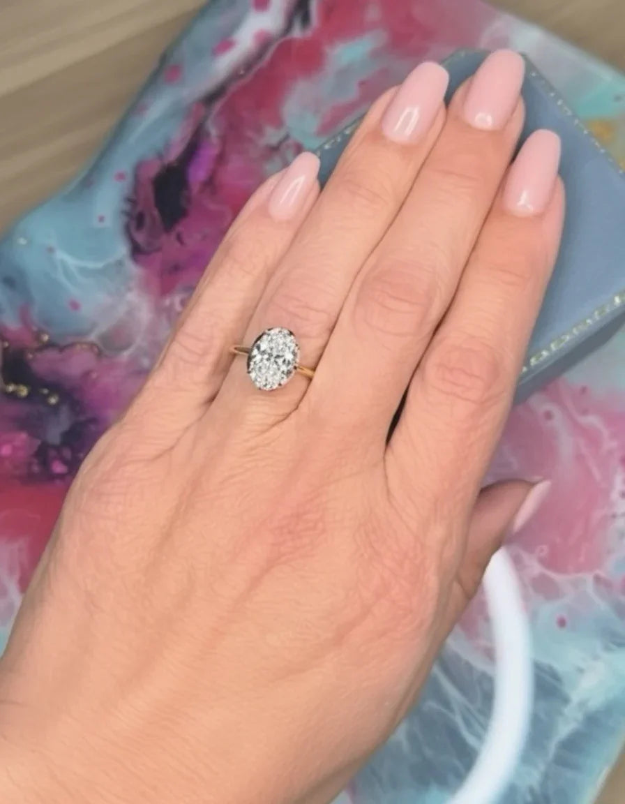 Oval diamond engagement ring on hand with gold band, custom jewelry design