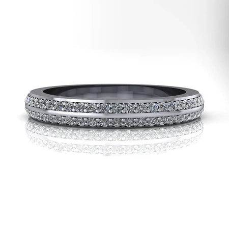 White gold diamond eternity band with double row pavé setting, reflected on white surface