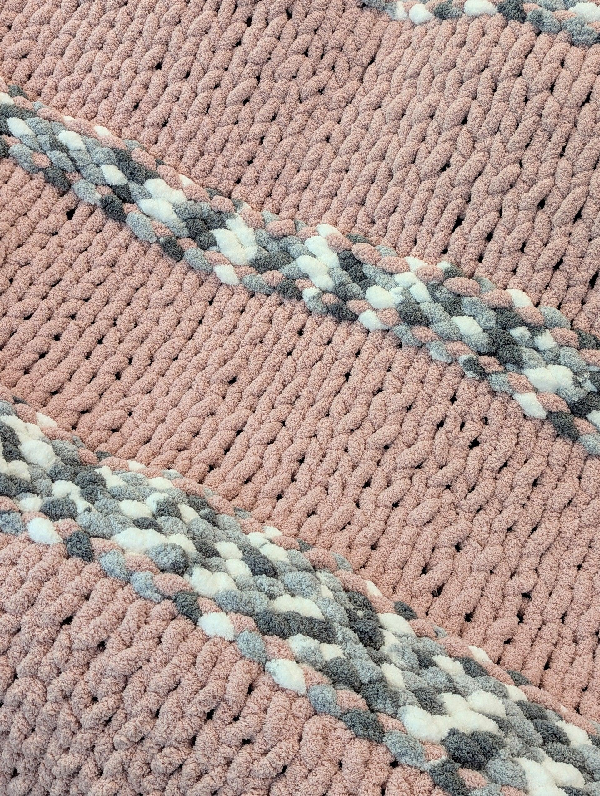 Chunky knit pink and gray blanket with braided diagonal stripes, textured home decor