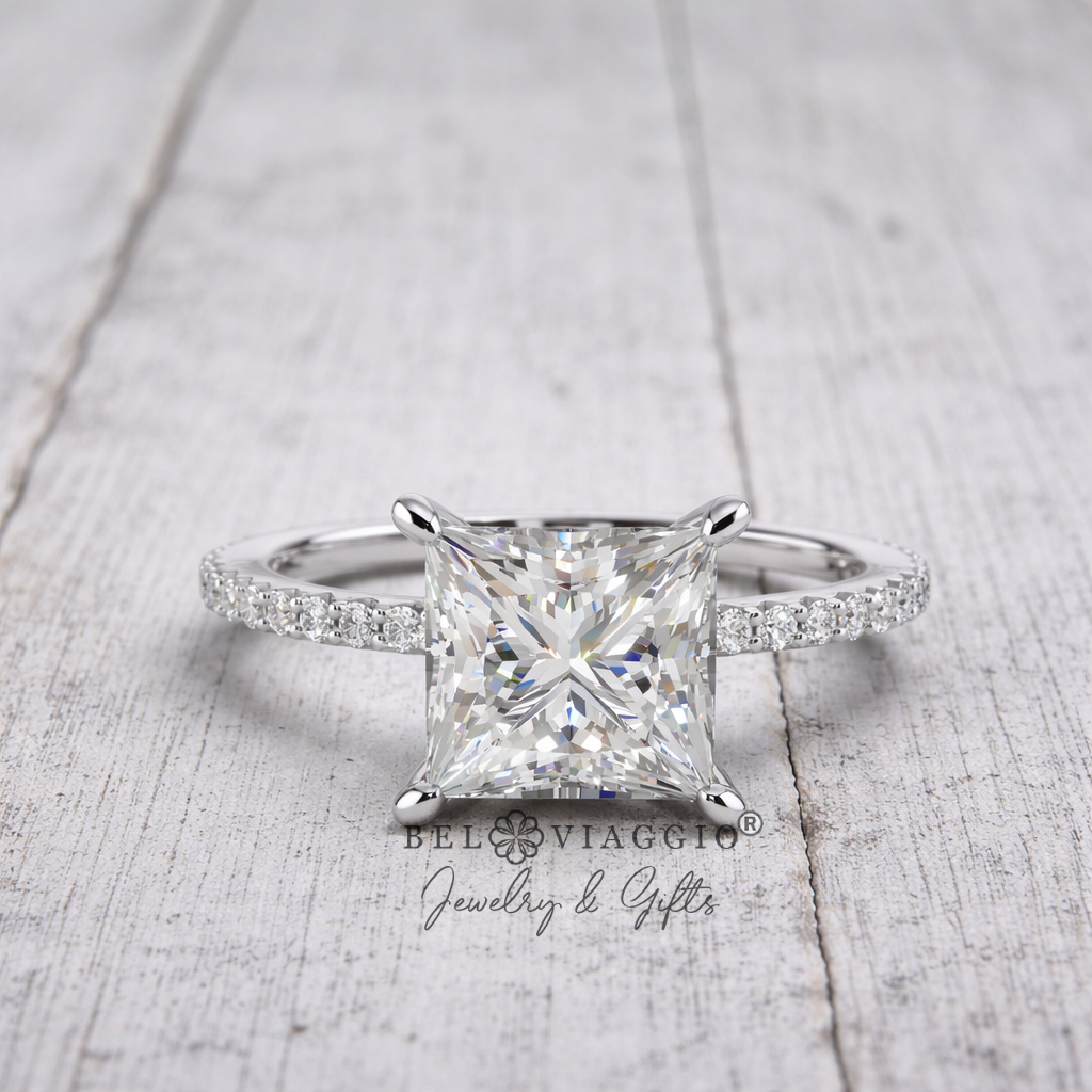 Princess cut diamond engagement ring with pavé band on rustic wood background