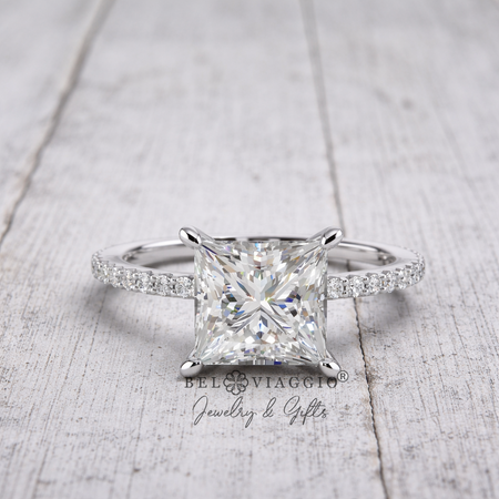 Princess cut diamond engagement ring with pavé band on rustic wood background