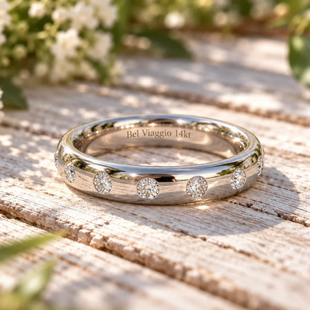 Bel Viaggio Designs flush set 14kt gold wedding band with lab diamonds on a rustic wood surface