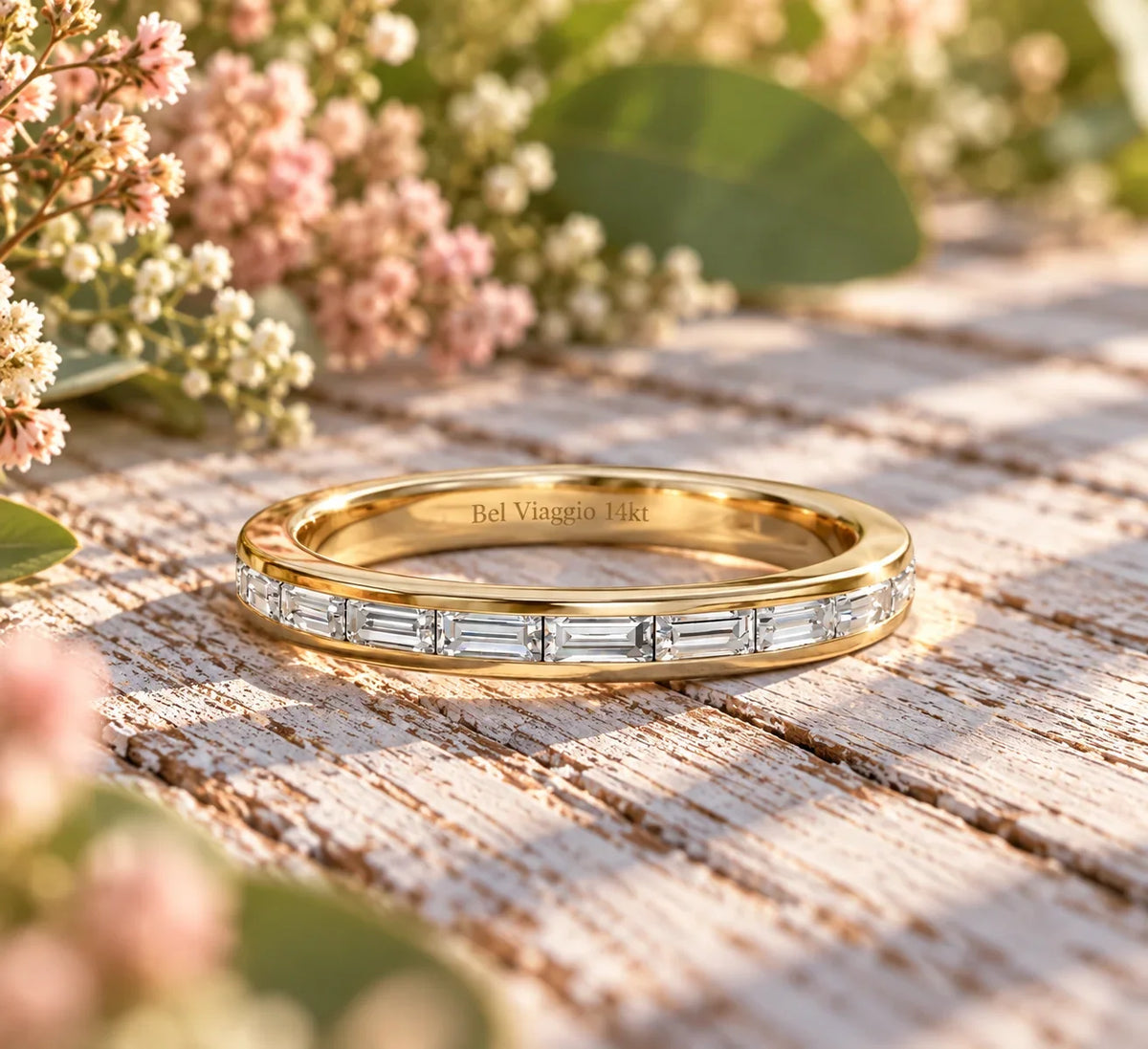 Bel Viaggio Designs lab diamond baguette wedding band in 14kt gold on a rustic wooden surface