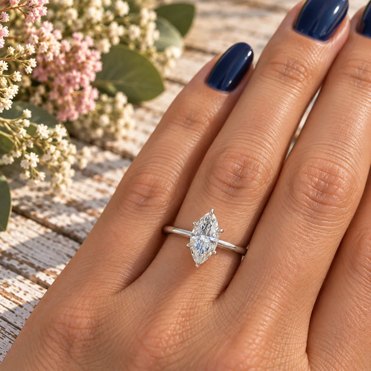 Lab Diamond Marquise Engagement Ring by Bel Viaggio Designs on a hand with blue nails