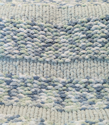 Close-up of textured knitted fabric with blue, white, and gray yarn pattern