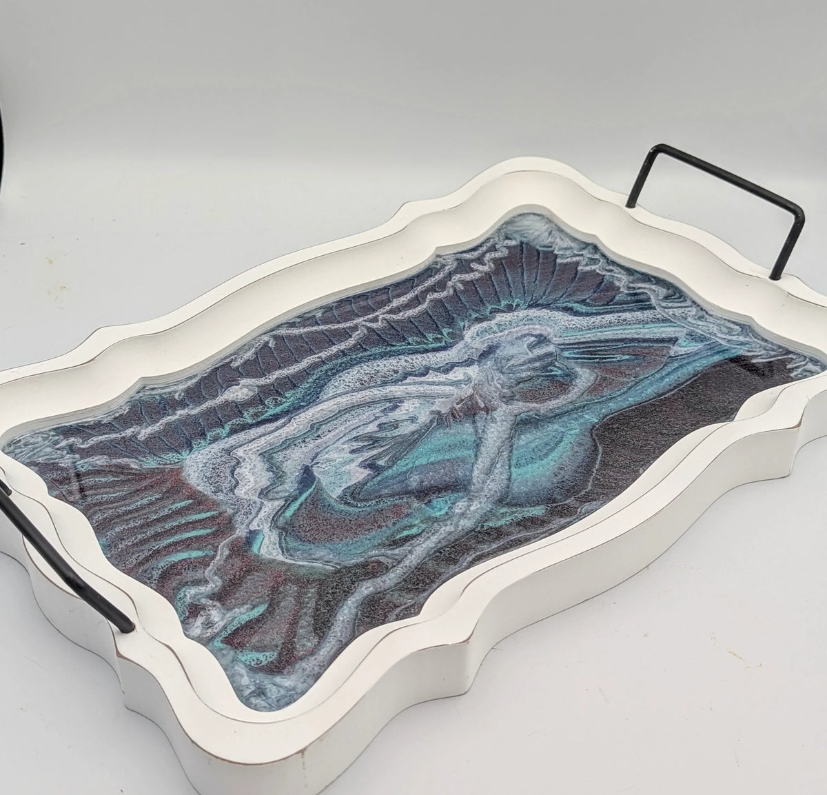 Decorative tray with white scalloped edges, marble pattern, and black metal handles