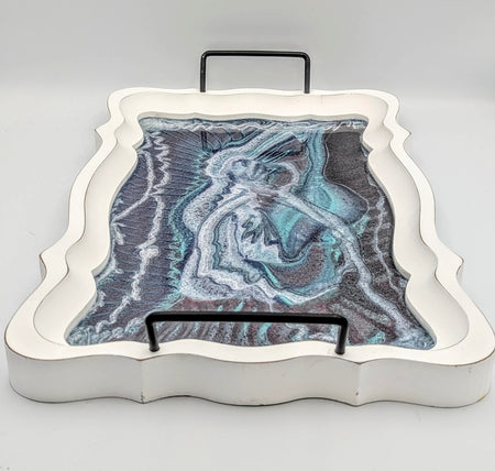 Decorative serving tray with abstract resin art in blue, white, and black tones, curved edges