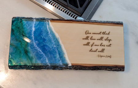 Epoxy resin ocean art wood serving board with Virginia Woolf quote, on kitchen counter