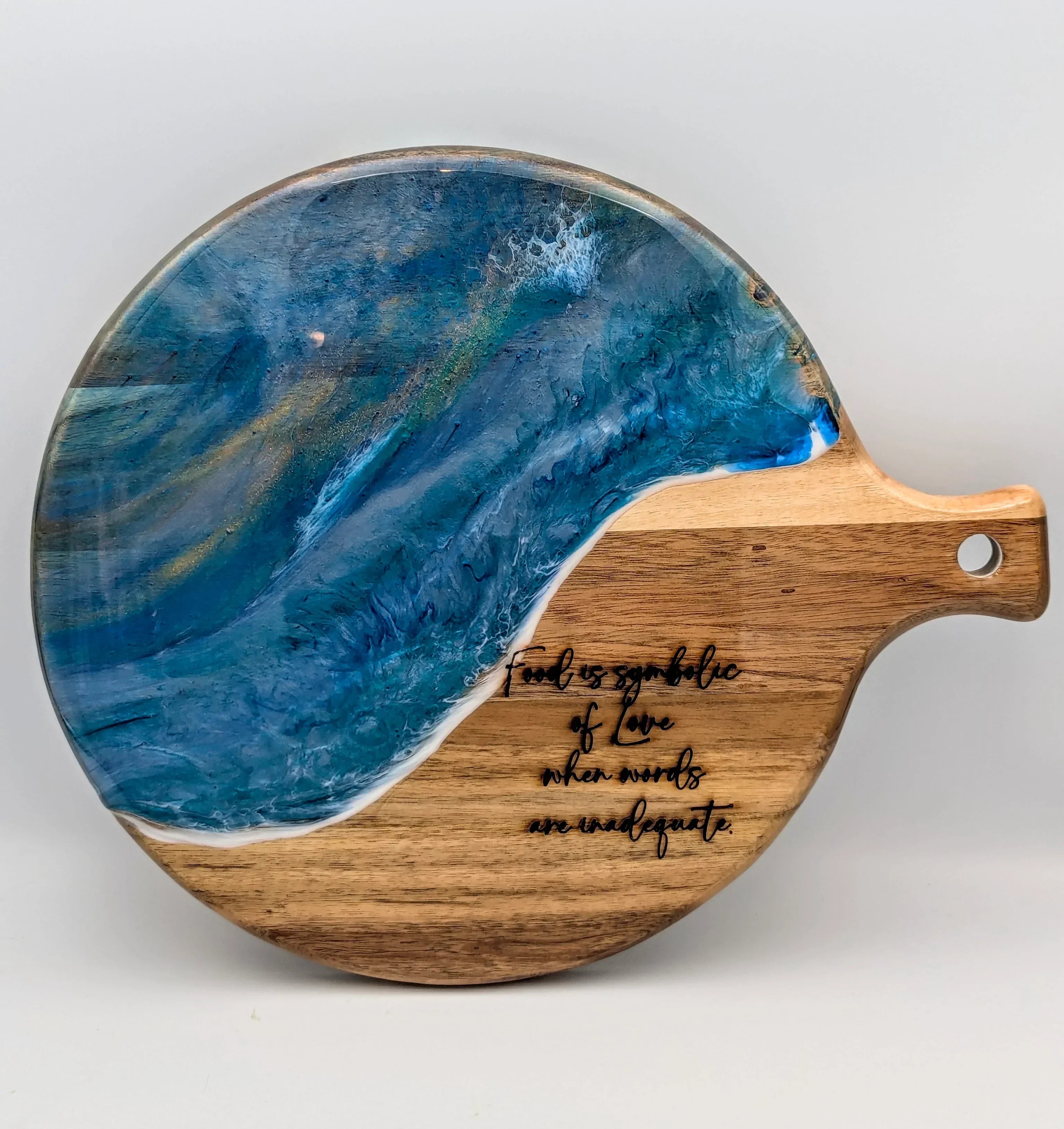Round wooden serving board with blue resin ocean wave design and engraved quote, food gift idea