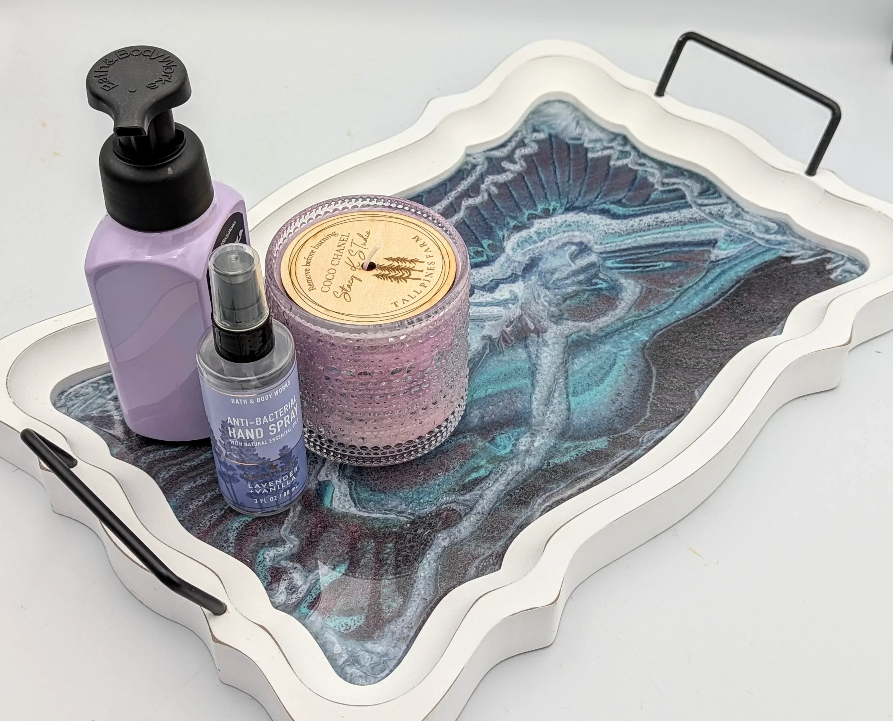 Decorative tray with lavender hand soap, antibacterial hand spray, and a pink candle