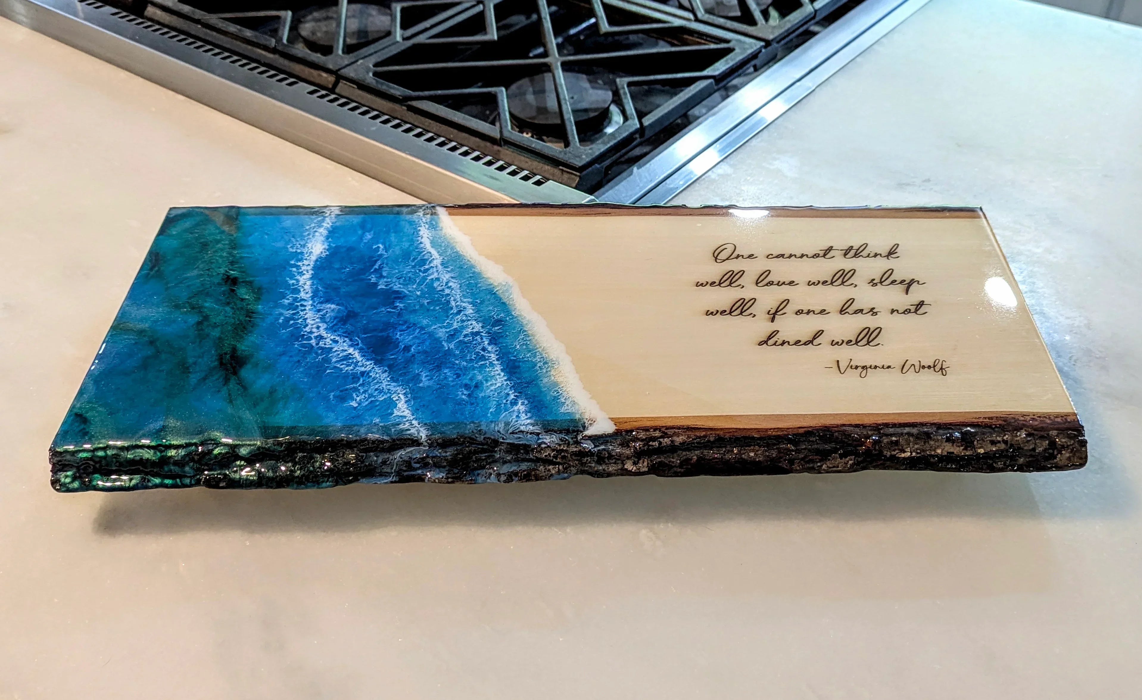 Resin ocean art wood serving board with Virginia Woolf quote on kitchen counter