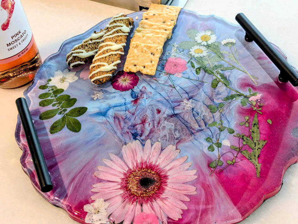Floral resin tray with embedded flowers, crackers, and biscotti, paired with pink moscato wine.