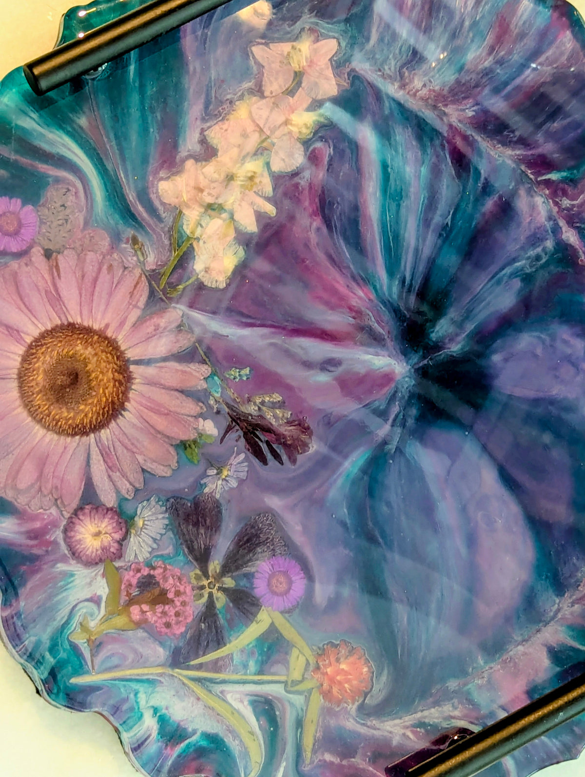 Epoxy resin art tray with pressed flowers, vibrant purple and teal swirls, perfect for custom jewelry display.