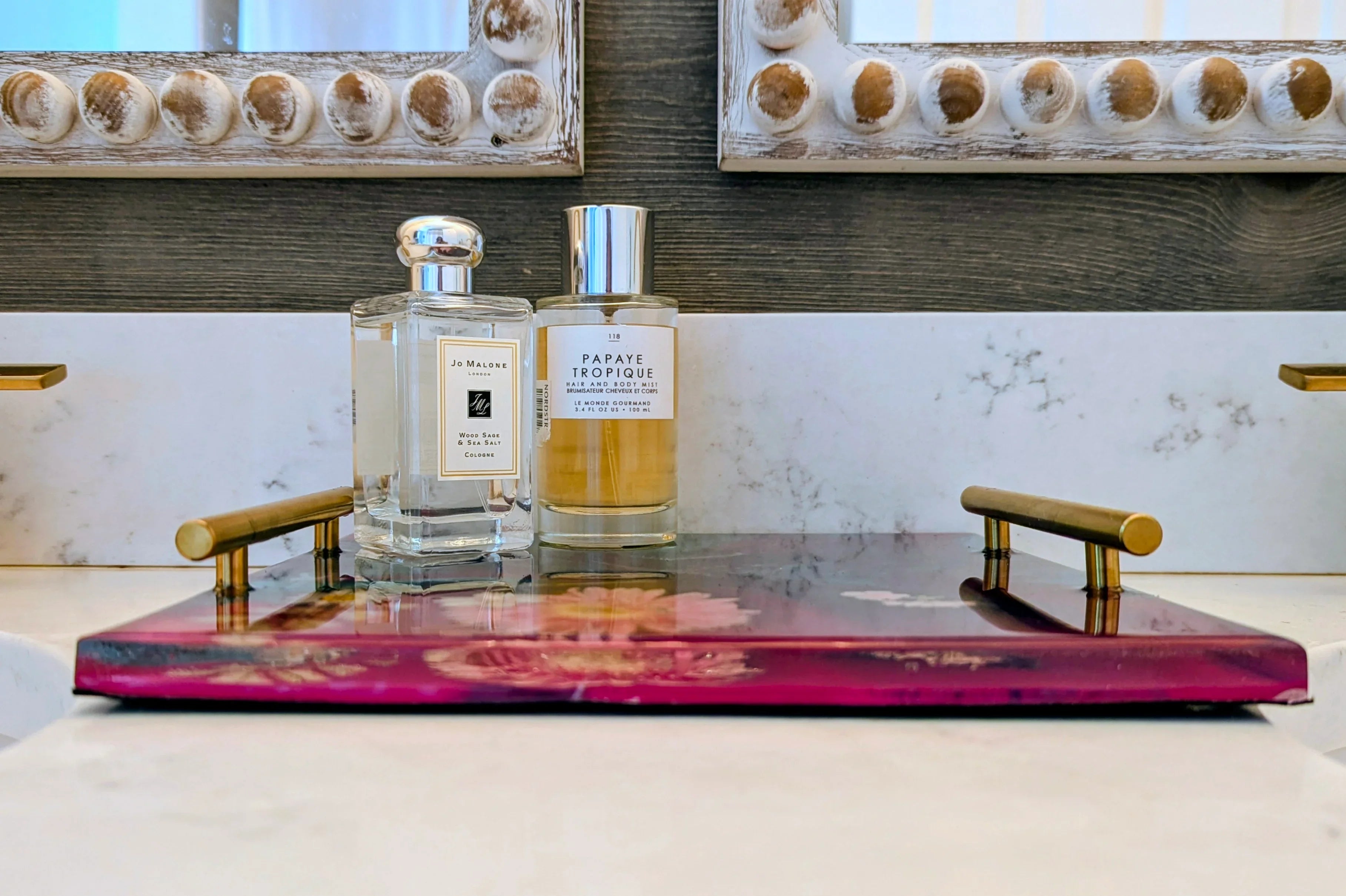 Luxury perfume bottles on a decorative tray in a stylish bathroom setting