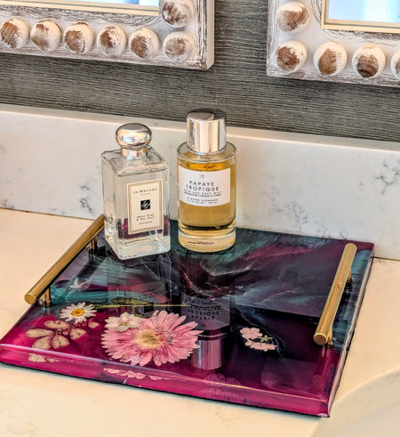Epoxy resin tray with dried flowers, holding perfume bottles on marble vanity, decorative home accessory