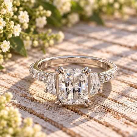 Bel Viaggio Designs lab diamond radiant three stone engagement ring on a rustic wood background