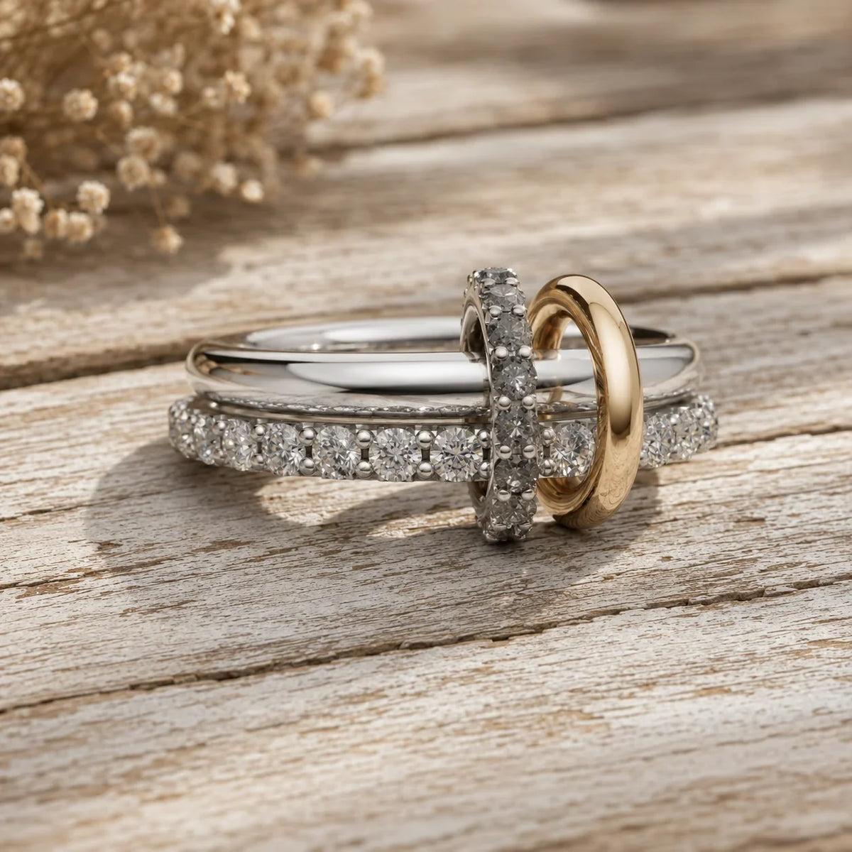 Elegant diamond engagement rings with gold and silver bands on rustic wood