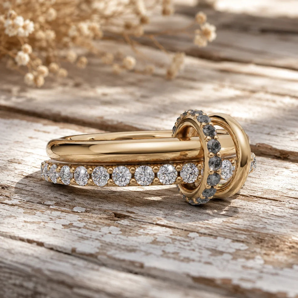 Elegant gold engagement ring with diamond band, set on rustic wood with dried flowers