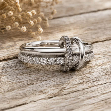 Elegant diamond engagement ring set with pave band, displayed on rustic wood with dried flowers