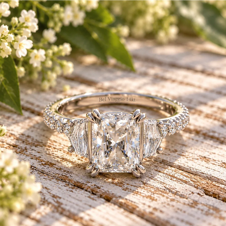 Bel Viaggio Designs lab diamond radiant and cadillac three stone ring on a wooden surface