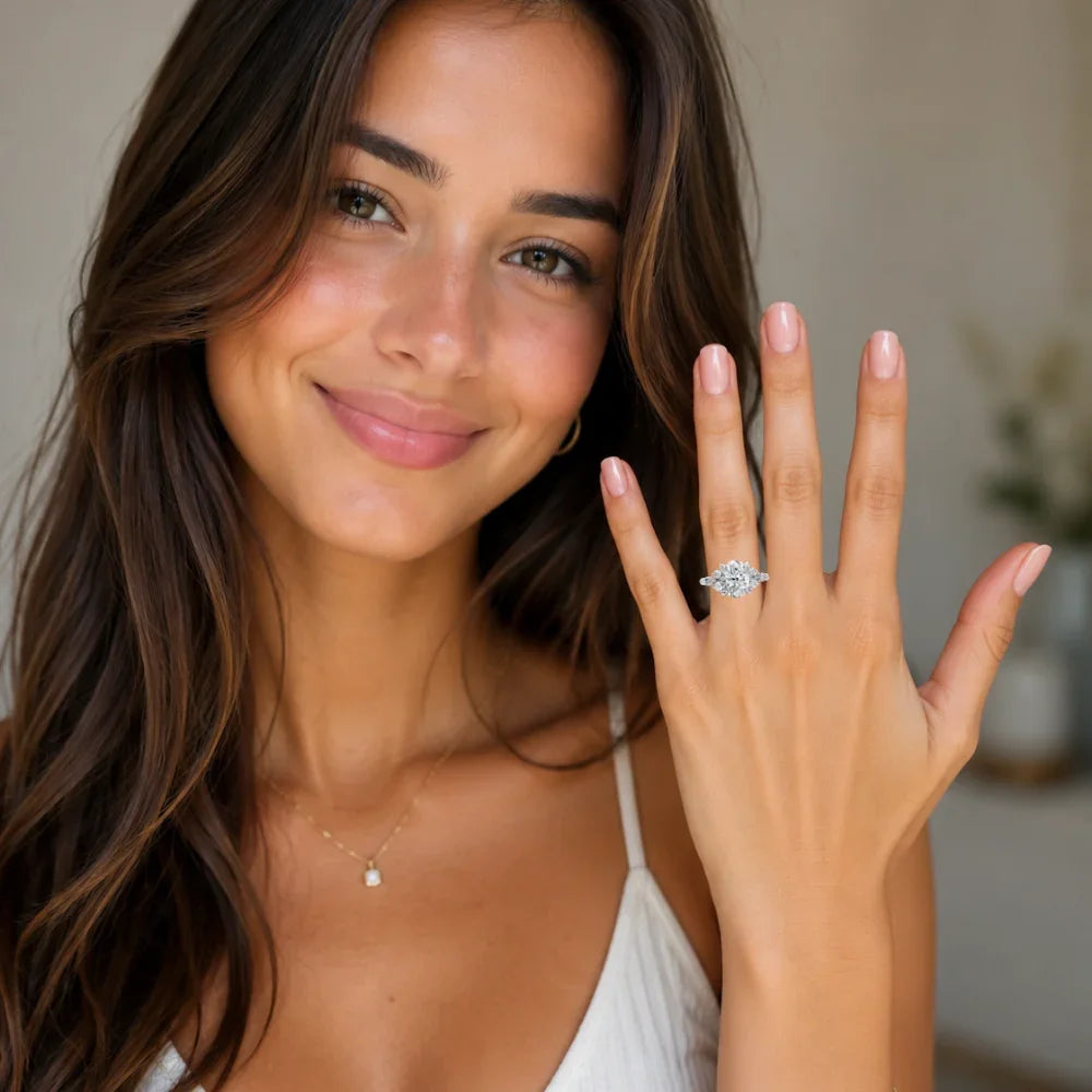 Woman smiling with custom engagement ring featuring oval diamond and halo setting