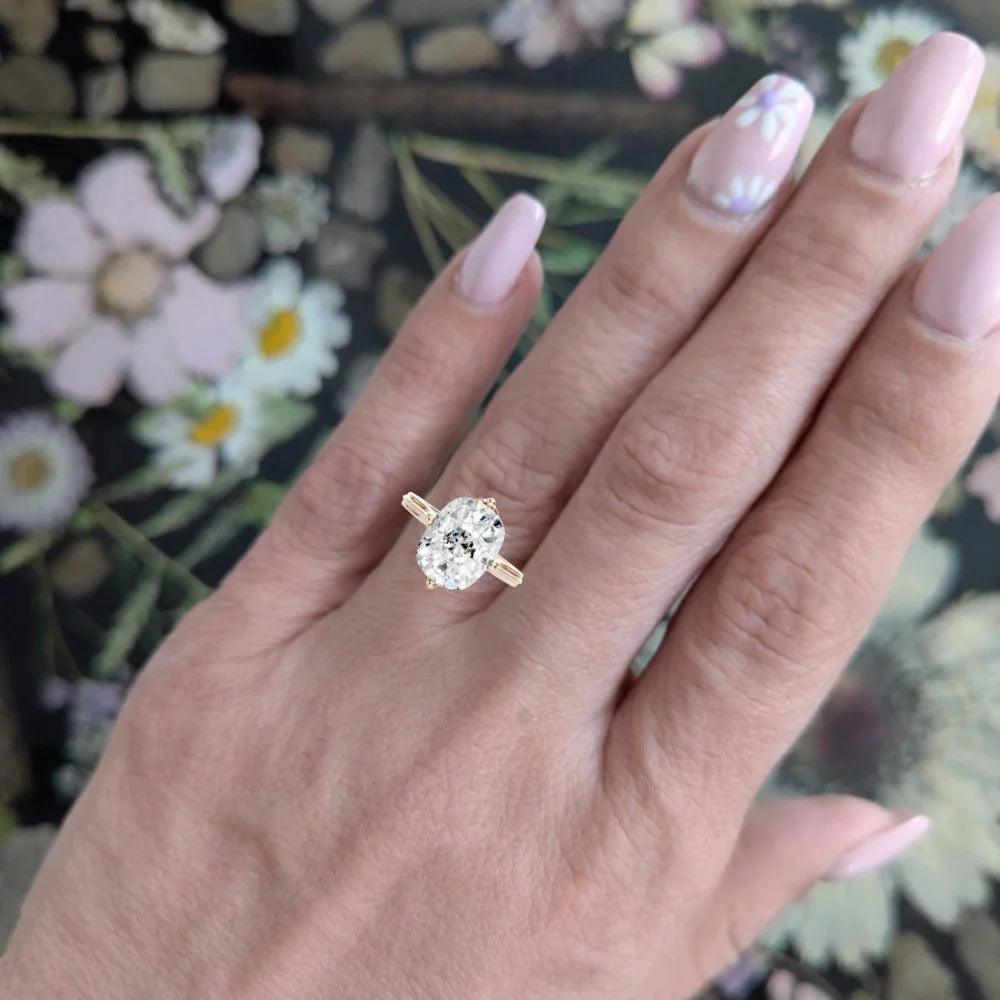 Oval diamond engagement ring on finger, rose gold band, floral background