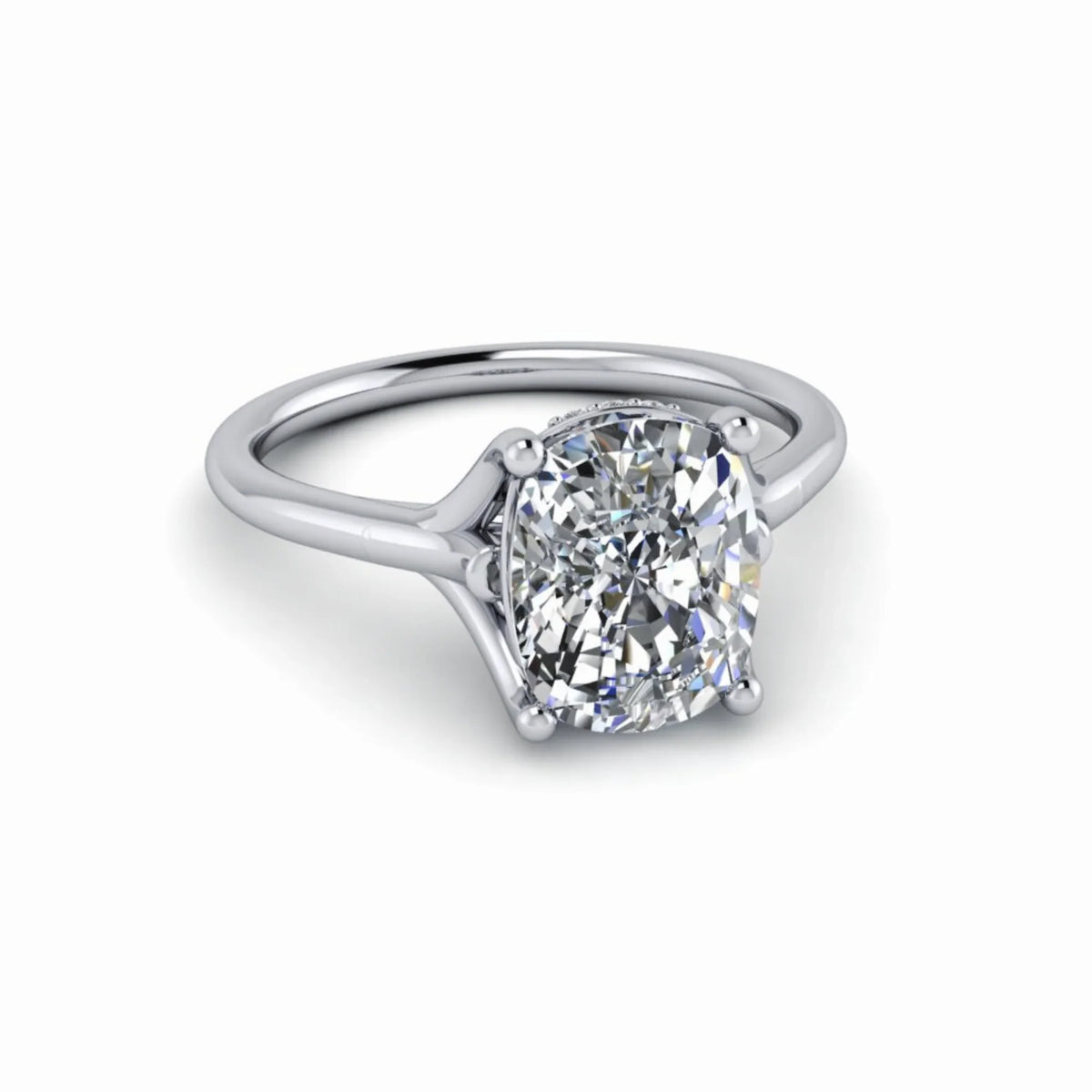 Cushion cut diamond solitaire engagement ring with white gold band on white background