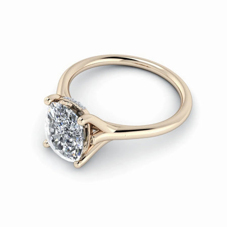 Oval diamond solitaire engagement ring with yellow gold band on white background