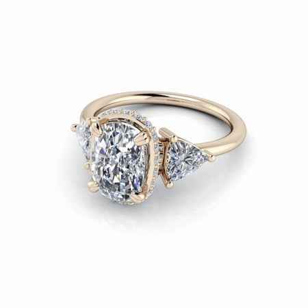 Oval diamond engagement ring with side stones in a yellow gold setting on white background