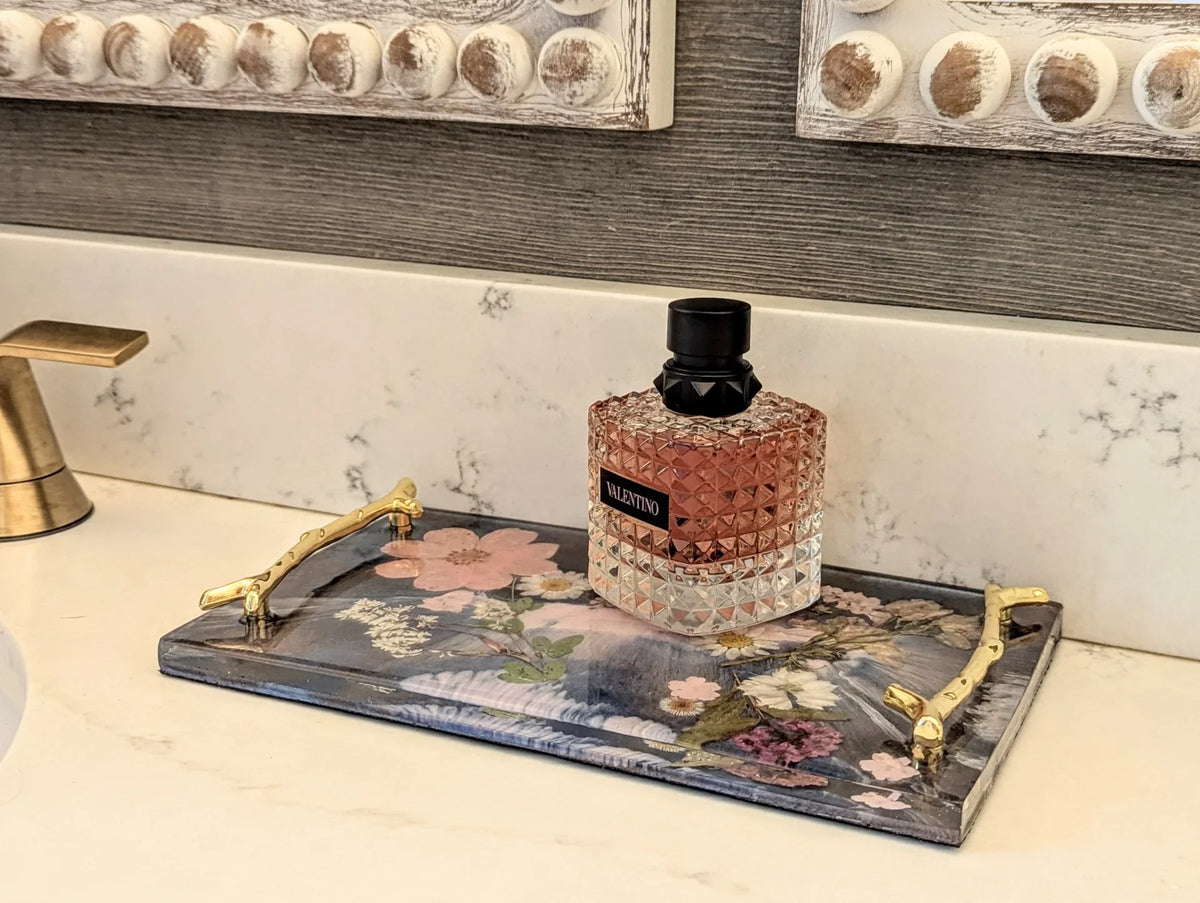 Stacy K Studio floral resin vanity tray with gold handles holding a perfume bottle.