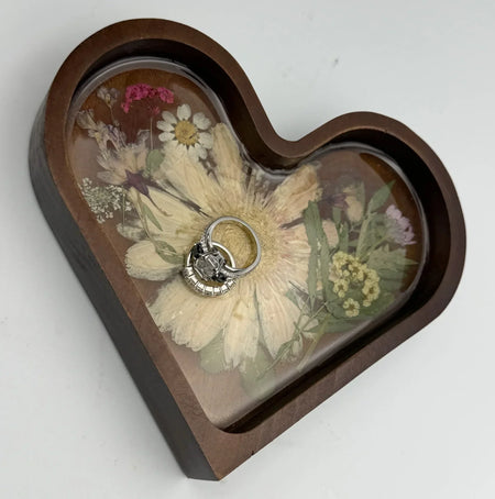 Custom silver engagement ring on heart-shaped pressed flower jewelry tray