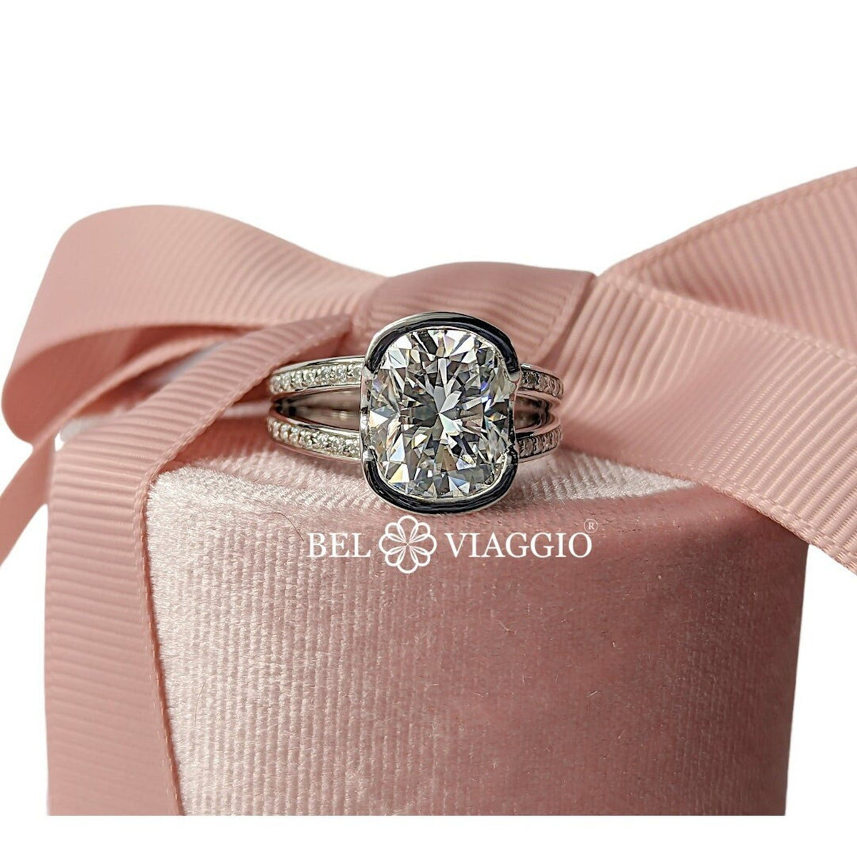 Cushion cut moissanite engagement ring by Bel Viaggio Designs on a pink jewelry box with a bow