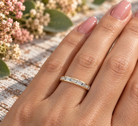 Bel Viaggio Designs lab diamond baguette wedding band in gold on a woman's finger