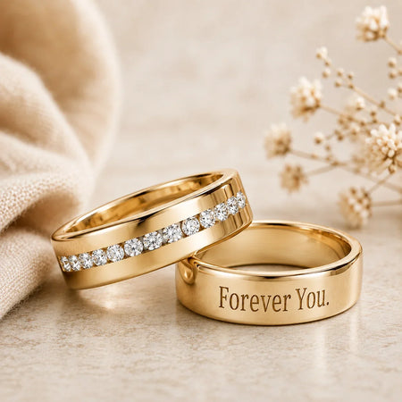 Two custom gold wedding bands, one with diamonds and one engraved with Forever You.