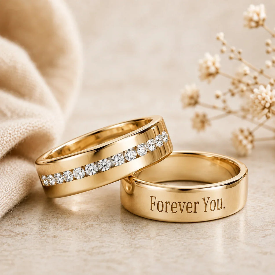 Two custom gold wedding bands, one with diamonds and one engraved with Forever You.