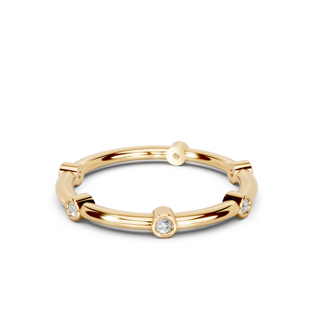 Gold band ring with round bezel-set diamonds in a modern minimalist style