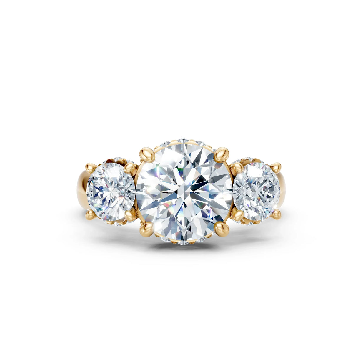 Three-stone gold engagement ring with round brilliant diamonds on white background