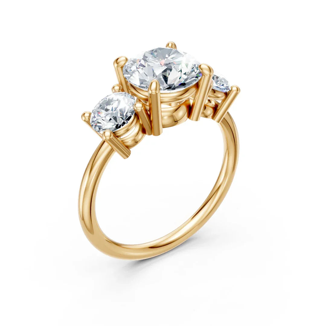 Three stone gold engagement ring with round brilliant diamonds on white background