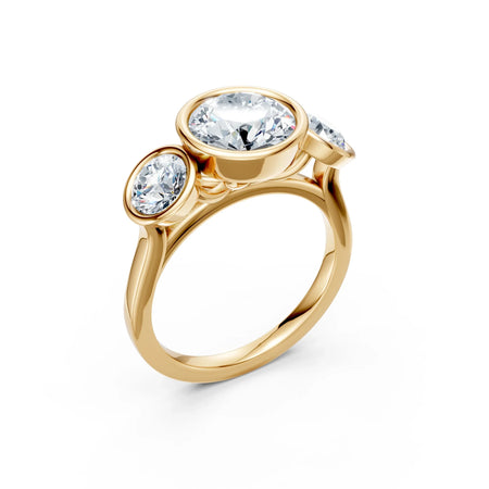 Three stone gold engagement ring with round white gemstones on white background