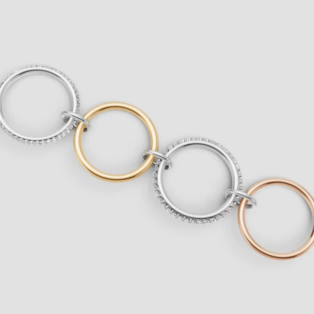 Three-tone gold and diamond interlocking circle bracelet on white background